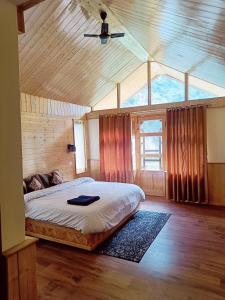 - une chambre avec un lit dans une maison en bois dans l'établissement Cliff Haven Tirthan, à Banjār