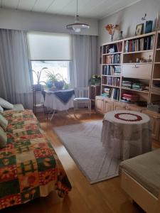 a living room with a table and a book shelf at Talo Porokylä - Nurmes in Nurmes