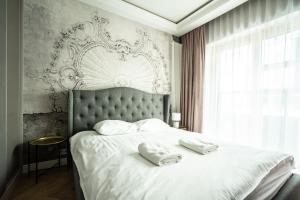 ワルシャワにあるVipWarsawApartments Sapphire Mennica Residenceのベッドルーム1室(ベッド1台、タオル2枚付)