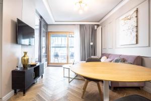 een woonkamer met een tafel en een bank bij VipWarsawApartments Sapphire Mennica Residence in Warschau