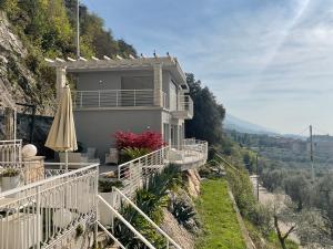 ein Haus an der Seite eines Hügels mit einem Regenschirm in der Unterkunft Villa Gabizza villa singola con jacuzzi privata in Malcesine