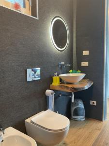 ein Badezimmer mit einem weißen WC und einem Waschbecken in der Unterkunft Villa Gabizza villa singola con jacuzzi privata in Malcesine