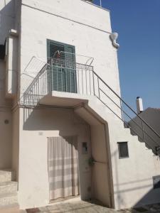 ein weißes Gebäude mit einer Treppe und einem Fenster in der Unterkunft All'antico orologio da Maria in Miglionico