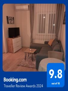 a living room with a couch and a tv at Gray Apartament 2 Pristina in Prishtinë
