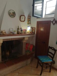 ein Wohnzimmer mit einem Kamin und einem Stuhl in der Unterkunft All'antico orologio da Maria in Miglionico