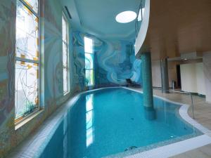 - une grande piscine dans un bâtiment avec piscine dans l'établissement Apartment Promenáda 35, à Karlovy Vary