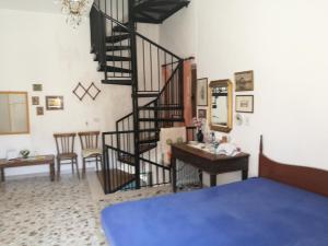 ein Wohnzimmer mit einer Wendeltreppe und einem Schreibtisch in der Unterkunft All'antico orologio da Maria in Miglionico