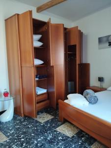 a bedroom with two beds and a large wooden closet at La Maddalena b&b da Marco in La Maddalena