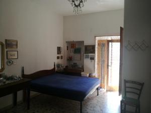 Schlafzimmer mit einem Bett, einem Schreibtisch und einem Fenster in der Unterkunft All'antico orologio da Maria in Miglionico