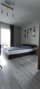 Una cama grande en una habitación con una ventana grande. en Flamingo 31, en Międzyzdroje