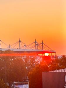 einen Sonnenuntergang mit einer Brücke im Hintergrund in der Unterkunft Cozy nest 10mn from Stade de France in Aubervilliers