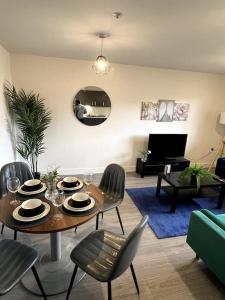 a living room with a table and chairs and a piano at Spacious One Bedroom Apartment in Hemel Hempstead