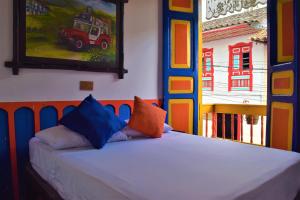 Bett in einem Zimmer mit Wandgemälde in der Unterkunft FILANDIA HOTEL in Filandia