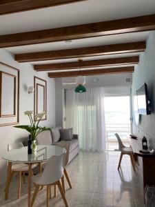 a living room with a couch and a table and chairs at Skizenas Waterfront Apartments in Haraki