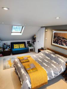 a bedroom with a large bed and a couch at Large light loft room - en suite in Brighton & Hove