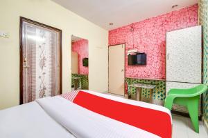 a bedroom with a bed and a red wall at SPOT ON Hotel Wonderfull Inn in Visakhapatnam
