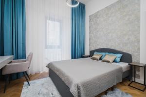 a bedroom with a bed and a desk and a chair at Palace Dlazdena – Stylish Prague Centre Apartment in Prague