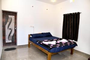 Bett in einem Zimmer mit einem schwarzen Vorhang in der Unterkunft Niyam Beach Stay in Gokarna