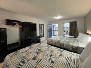 a hotel room with two beds and a desk at Studio 6 Conroe, TX in Conroe