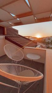 a balcony with a bed and two chairs and a table at Luvi Kaş Otel - Adults Only (+16) in Kas