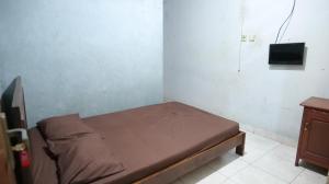 a small bed in a room with a tv on the wall at Hotel Pelangi HS in Ngabean