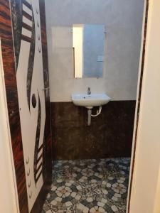 a bathroom with a sink and a mirror at Niyam Beach Stay in Gokarna