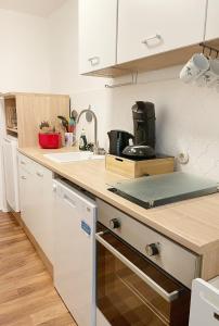 uma cozinha com armários brancos e uma bancada em Haus Waldblick em Philippsreut