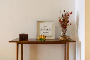 une table avec un vase de fleurs et une photo dans l'établissement Departamento familiar con excelente ubicación - BA 3, à Buenos Aires