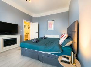 a bedroom with a large bed and a tv at Botanic Rooms in Liverpool