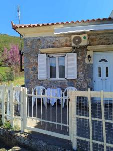 una casa con una valla y sillas delante de ella en Dina's House, en Leondari