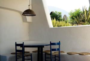 mesa y sillas en una habitación con ventana en Pantelleria, villetta sul mare, en Scauri