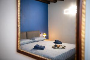 a mirror reflecting a bedroom with a bed with blue walls at Casa sul Porto in Desenzano del Garda