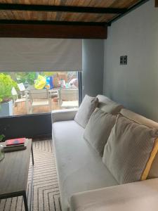a living room with a white couch and a table at Guest Tiny House - lake side in Montevideo