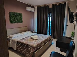 Dormitorio con cama, escritorio y TV en Calipso, en Catania