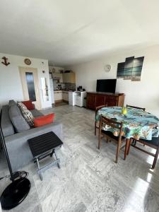 uma sala de estar com um sofá e uma mesa em Grand studio vue mer - Plages à pied - Parking em Antibes