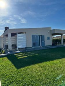 une maison blanche avec une pelouse devant elle dans l'établissement Cava Del Sol, à Augusta