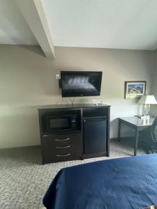 a hotel room with a bed and a flat screen tv at Garner INN & Suites 