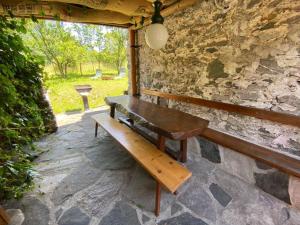a wooden bench sitting on a stone wall at LA GRAA in Piuro