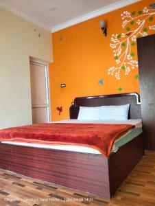 1 dormitorio con 1 cama grande y pared de color naranja en Silver Mist villa, en Kodaikanal