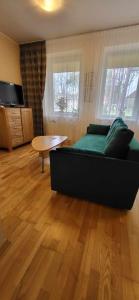 a living room with a couch and a table at AQUA Apartamentai prie AQUA PARKO in Druskininkai