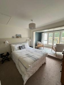 Un dormitorio con una gran cama blanca y una ventana. en Tower House, Cowes Old Town, en Cowes