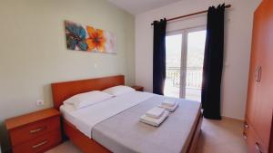 1 dormitorio con 1 cama con 2 toallas en Amarildo Hotel, en Himare