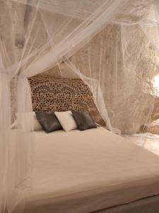 a bedroom with a bed covered in mosquito nets at Stone House in Matera