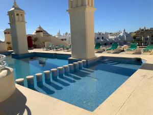 a swimming pool in a resort with chairs and tables at Piso islas C111 in Benalmádena
