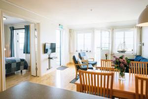 ein Wohnzimmer mit einem Tisch und Stühlen sowie ein Wohnzimmer in der Unterkunft Ekenäs Havshotell in Sydkoster