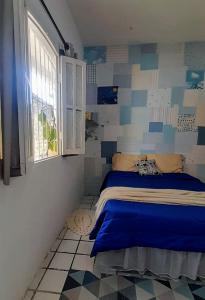 una camera con un letto in una stanza con una finestra di Hospedaria Guapê a Lauro de Freitas