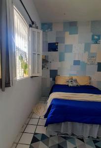 a bedroom with a bed in a room with a window at Hospedaria Guapê in Lauro de Freitas