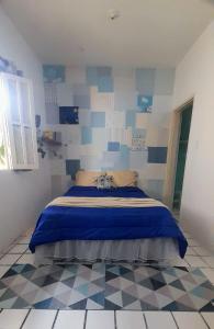 una camera con letto e pareti bianche e blu di Hospedaria Guapê a Lauro de Freitas