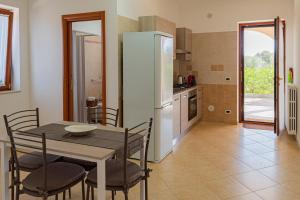 a kitchen and dining room with a table and a refrigerator at Country Home in Crispiano +8 photos
