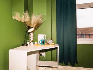 a green room with a white desk with a lamp at Botanic Rooms in Liverpool